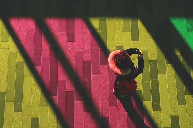 žena fotící s chytrým telefonem na barevném pozadí